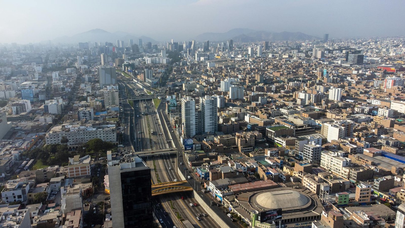 Vista aérea panorámica de Lima mostrando la trama urbana y la división entre distritos, contexto de la conversación cotidiana sobre la ciudad.