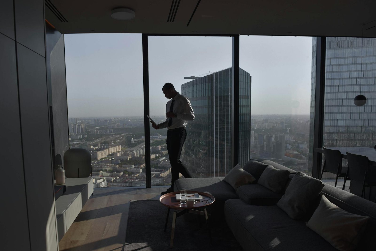Silueta de ejecutivo en apartamento de lujo con vista panorámica de la ciudad