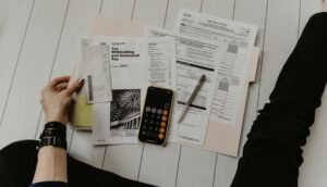 Mesa de reunión con planos arquitectónicos y documentos financieros